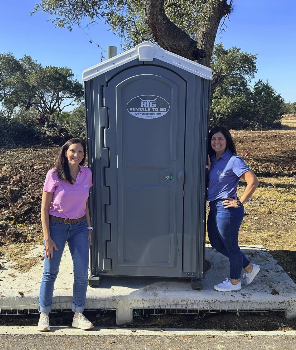 The Rentals To Go team with a portable restroom